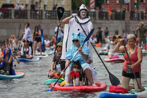 Participantes disfrazados navegan en paddle surf por el río Moyka durante festival en San Petersburgo